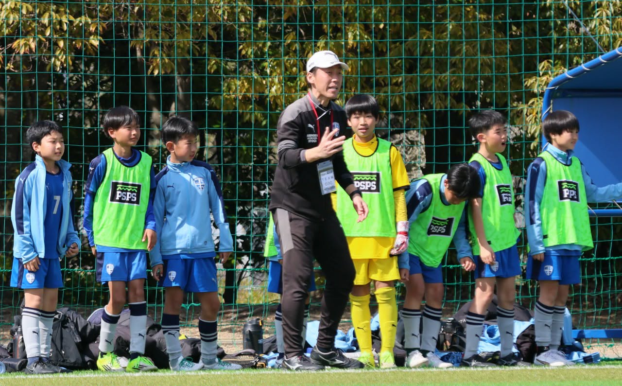 サッカーチームの子どもたちと立つ中村ちから