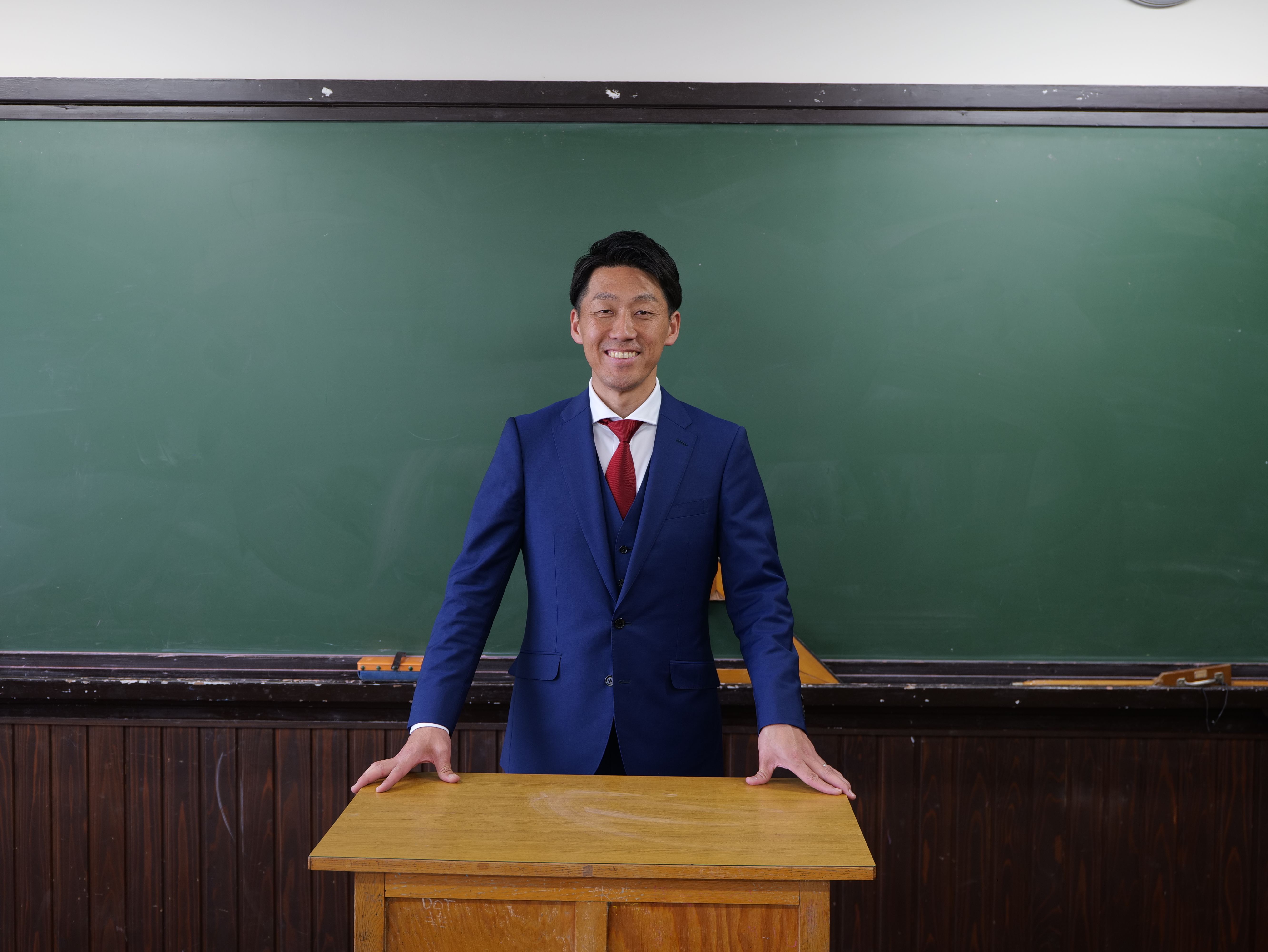 黒板の前に立つ現在の中村ちから