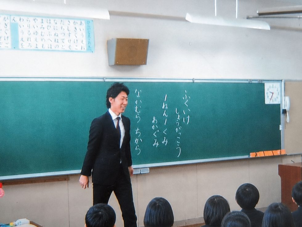教員時代、教室で子どもたちの前に立つ中村ちから
